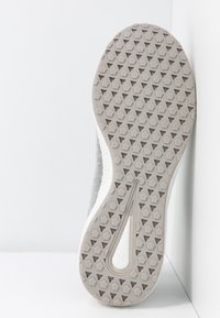 Semelle de chaussure avec des motifs de semelle hexagonaux et triangulaires en gris clair, affichant la taille numéro 37 près de la zone de la voûte.
