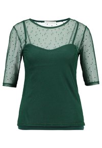 Top verde transparente con mangas cortas, textura de puntos, diseño en capas sobre un verde sólido por debajo, cuello redondeado y tejido suave.