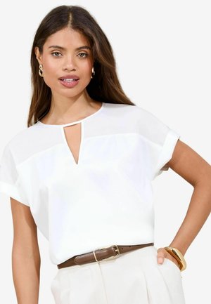 White blouse with a keyhole neckline and short rolled sleeves, paired with a brown belt. Smooth texture and minimalist design.