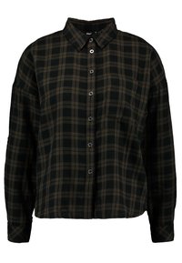 Chemise à carreaux noir et olive avec un col, des manches longues et une poche poitrine. Fabriquée en tissu doux et texturé.