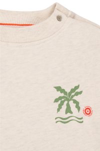 Felpa beige chiaro con colletto a coste, caratterizzata da una grafica di foglia di palma verde e un logo circolare rosso in basso a destra.