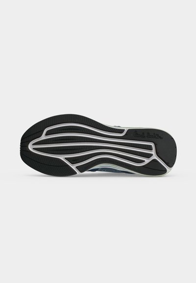 Semelle d'une basket avec des motifs en caoutchouc texturés noir et blanc et le logo "Paul Smith" embossé près du talon.