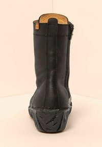 Bota de cuero negra hasta la mitad de la pantorrilla con costuras visibles, cremallera lateral, suela de goma texturizada y forro interior color beige.