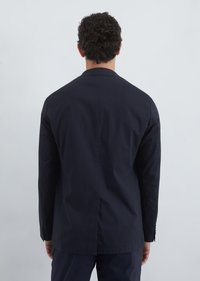 Navy blazer with a notched collar, single vent, and buttoned cuffs. Made of smooth fabric, featuring a tailored silhouette and minimalist design.