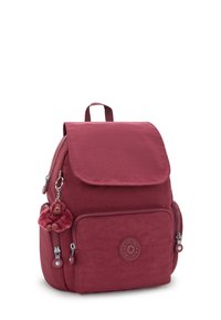 Vinröd tygryggsäck med klaffstängning, två blixtlåsfickor på sidorna och en rund logotyp. Innehåller en mjuk apa nyckelring som fäste.
