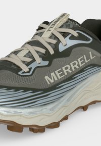 Gros plan d’une chaussure de trail Merrell grise et noire avec des lacets beige et une semelle extérieure marron texturée.