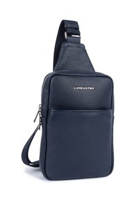 Borsa a tracolla in pelle blu navy con texture, tasca frontale con zip, tiretti in metallo argentato, tracolla regolabile e logo del marchio Lancaster sulla parte anteriore.