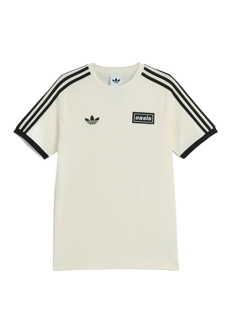 Maglietta bianca Adidas con strisce nere sulle maniche, polsini neri, logo Adidas sul lato sinistro del petto e patch "oasis" sul lato destro del petto.