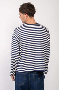 Granatowa i kremowa, w paski, koszula z długim rękawem wykonana z bawełny. Posiada okrągły dekolt oraz luźny fason, z lekko zaokrąglonym dołem z tyłu.