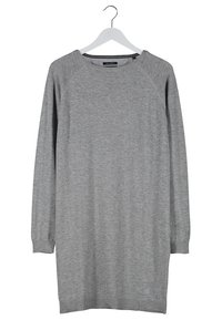 Robe pull en maille gris à manches longues suspendue sur un cintre blanc contre un fond blanc.