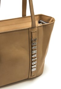 Borsa tote in pelle color cuoio dalla forma strutturata, con dettaglio logo in argento e cuciture semplici lungo i bordi. Tasca interna con cerniera.