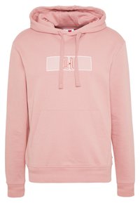 Sudadera con capucha rosa hecha de un tejido suave. Cuenta con un bolsillo frontal y cordones, con un detalle de logo bordado en el pecho.