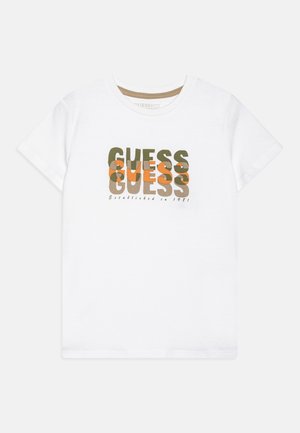 Biała koszulka z krótkim rękawem z nakładającym się zielonym i pomarańczowym napisem "GUESS" oraz napisem "Established in 1981" wydrukowanym pod logo.