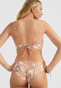 Bikini met verstelbare bandjes, bedrukt in warme tinten van perzik, blauw en wit; heeft een strik achterdesign en een medium-coverage broekje.