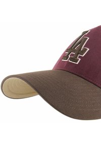 Cappellino da baseball color marrone scuro con visiera marrone, con logo "LA" ricamato in marrone e bianco sul davanti. Tessuto strutturato con una leggera lucentezza.