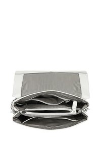 Borsa a mano bianca in pelle con interno in tessuto a strisce bianche e nere. Presenta più scomparti e una chiusura con zip.