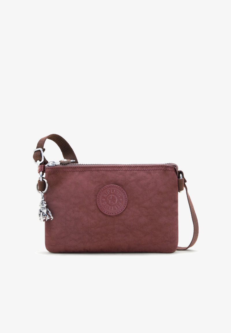 Bolsa burdeos con cremallera hecha de material sintético texturizado; cuenta con un charm decorativo y un parche de logo en relieve en la parte frontal.