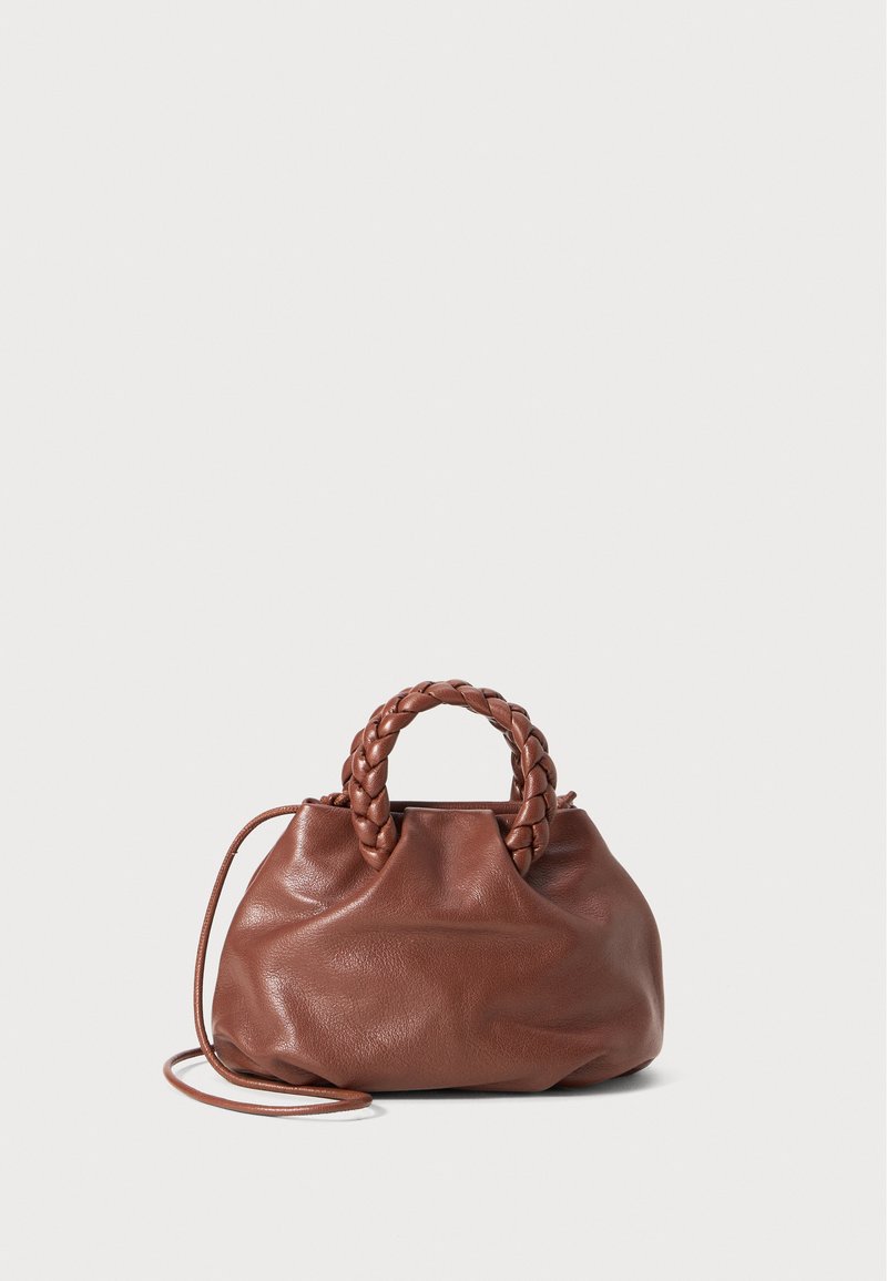 Barna bőr kézitáska fonott fogantyúval, ráncolt testtel és levehető pánttal. Texturált felület, puha, laza forma.