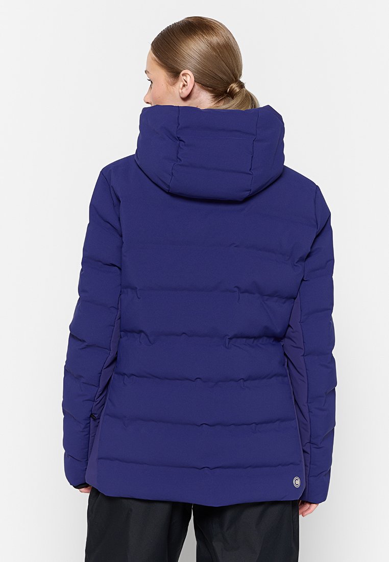 Giacca puffa blu navy con collo alto, cuciture orizzontali e dettaglio del logo sull'orlo. Presenta un cappuccio e una texture liscia.