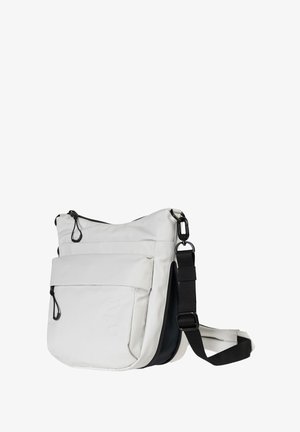 White fabric crossbody bag with a black strap, featuring a main zip compartment and a front pocket with a zip and pull tab detail.