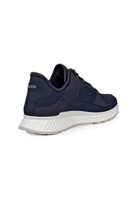 Dark blue sneaker with mesh and suede panels, white textured sole, and lace-up design shown from rear side angle.