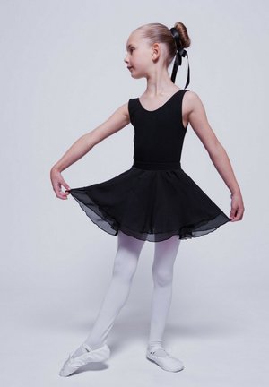 Black ballet leotard with attached sheer skirt, white tights, and soft ballet slippers. Hair in a bun secured with a black ribbon.