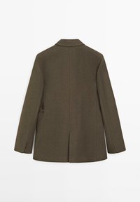 Blazer vert olive foncé ajusté avec épaules structurées, manches longues et fente centrale au dos, présenté de dos sur fond blanc.