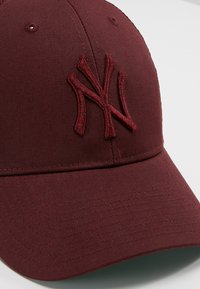 Cappellino da baseball bordeaux con logo NY ricamato, design strutturato, texture del tessuto liscia, visiera curva e occhielli di ventilazione.