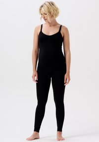 Zwarte zwangerschaps tanktop met verstelbare bandjes, gecombineerd met zwarte leggings. De stof is soepel en rekbaar, wat zorgt voor een strakke look.