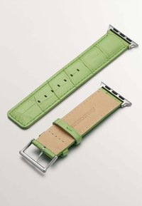 Correa de reloj de piel verde con estampado de cocodrilo, hardware plateado y parte inferior beige, con agujeros ajustables y costura en contraste.