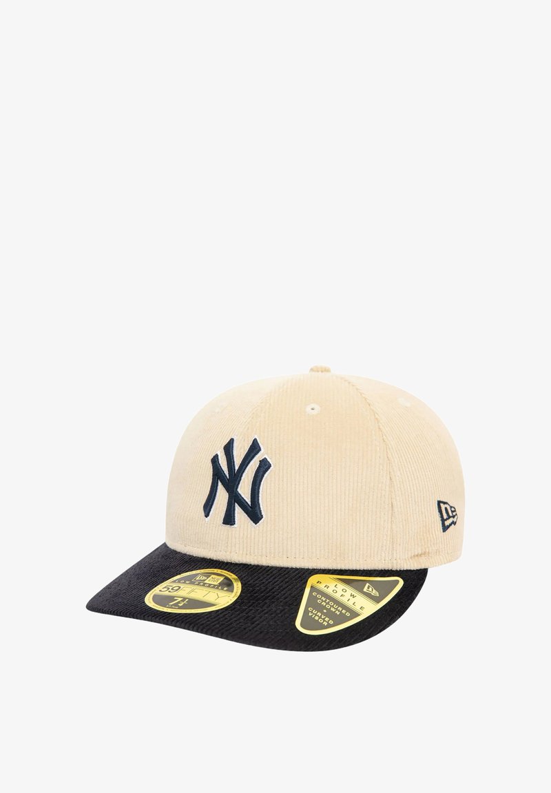 Gorra de pana caqui con visera negra, que presenta un logo de NY bordado en azul marino y dos etiquetas amarillas del producto en el borde.