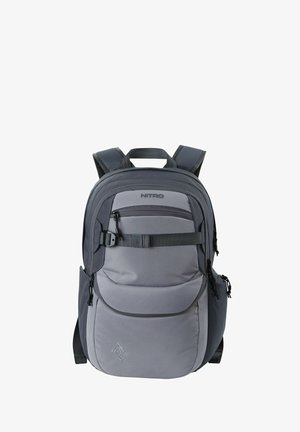 Zaino in tessuto grigio con spallacci regolabili, tasca frontale con zip, tasche laterali in rete e logo NITRO sulla parte anteriore, dotato di un pannello posteriore imbottito.
