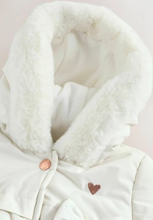 Veste d'hiver blanche avec une capuche en fourrure douce, un petit accent en forme de cœur scintillant et une fermeture à bouton en or rose.