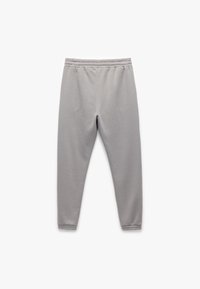 Grijze trainingsbroek met een elastische tailleband, taps toelopend ontwerp, zachte textuur en zonder zichtbare patronen of hardware-details.