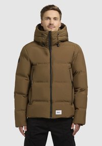 Brun pufferjacka med huva, dragkedja i fronten och sidofickor. Har svarta detaljer och ett justerbart snören i huvan.