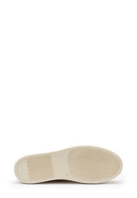 Suola della scarpa in off-white con un pattern testurizzato. Presenta design a onda e incrociati per presa e stabilità. Logo circolare presente.