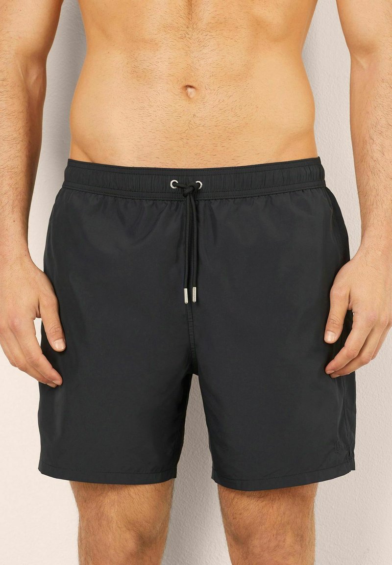Svarta badshorts i lättviktig tyg, med elastisk midja och snörning samt subtila horisontella sömdetaljer.