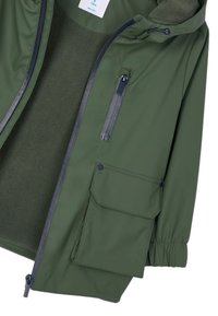 Chaqueta de exterior verde oliva con forro de forro polar, cierre frontal con cremallera, dos bolsillos, puños elásticos y capucha con cordón ajustable.