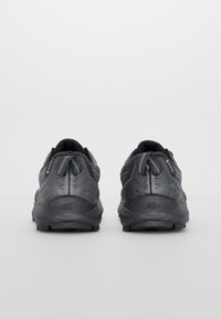 Zwarte sportschoenen met een textuurdesign, grijze accenten en een gevoerde zool. Inclusief een GORE-TEX-label op de hiel.