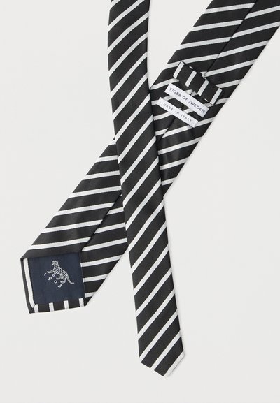 Γραβάτα με μαύρες και λευκές διαγώνιες ρίγες, με ετικέτες «Tiger of Sweden» και «Made in Italy» και μικρό λογότυπο τίγρης στην εσωτερική άκρη.
