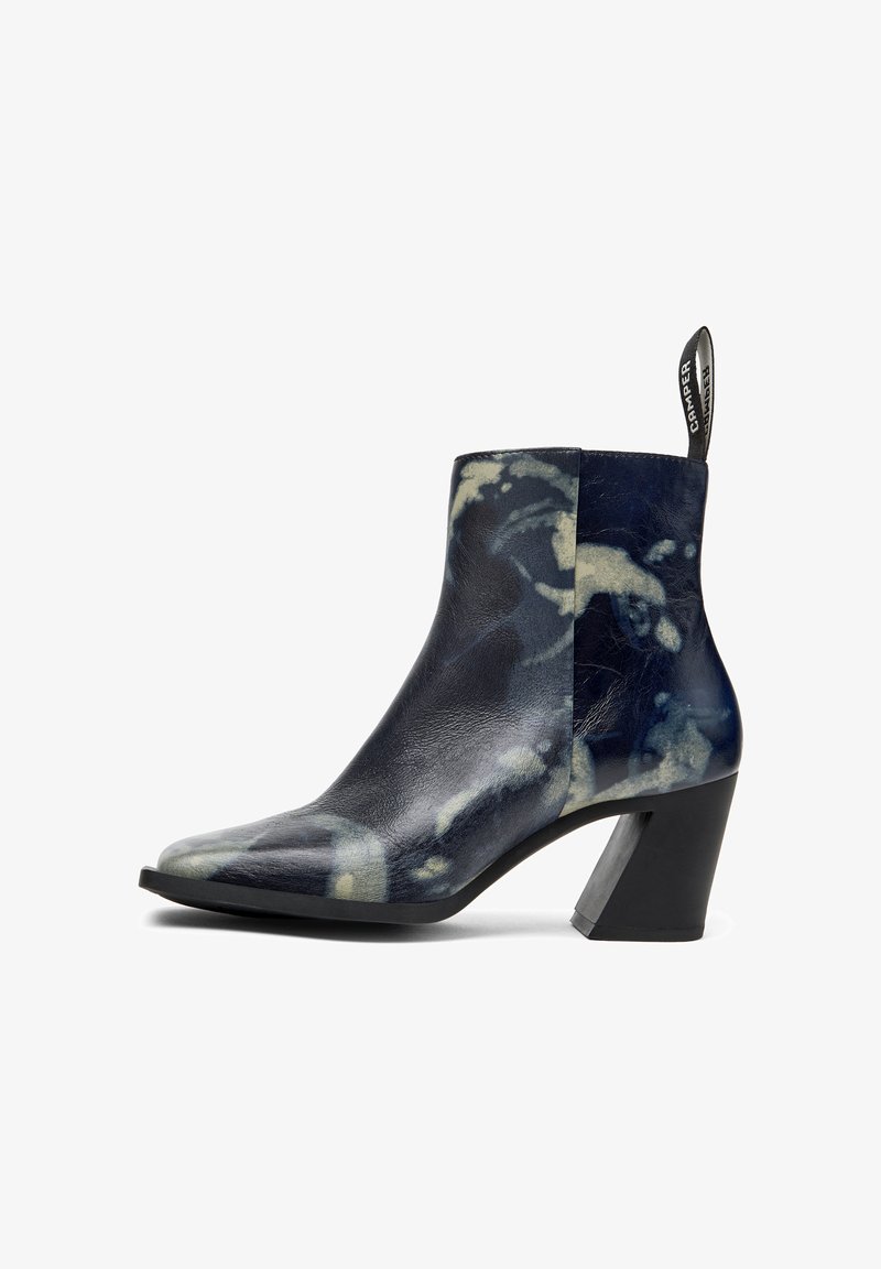 Stiefelette aus gemustertem Leder in Marineblau, mit Blockabsatz, spitzem Zehenbereich und einer Zuglasche mit Branding auf der Rückseite.