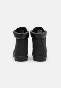 Black ankle boots with a smooth leather upper and padded collar. Features a rubber sole with textured tread. No visible laces or hardware.