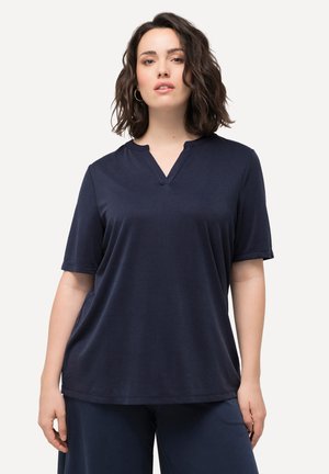 Chemise marine à manches courtes avec une texture douce, encolure en V et coupe décontractée, assortie à un pantalon sombre.