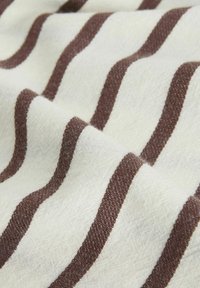 Soft fabric with brown and white horizontal stripes, shown with gentle folds enhancing texture and pattern detail.