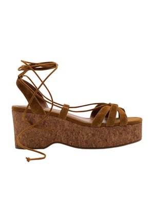 Brun ruskinds kilehæl sandal med korksål og omsluttende ankelremme, sidevisning på hvid baggrund.