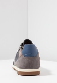 Baskets en daim et cuir avec un corps gris, un accent bleu au talon, un design à lacets et une semelle en caoutchouc. Dotées d'une fermeture éclair sur le côté.