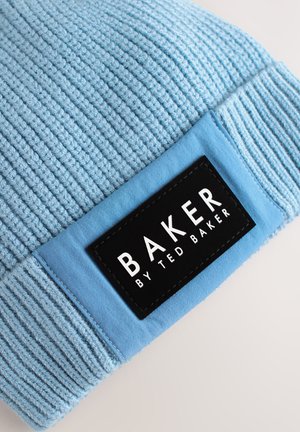 Lichtblauwe geribbelde gebreide muts met een aangehecht zwart label waarop in witte letters "BAKER BY TED BAKER" staat.