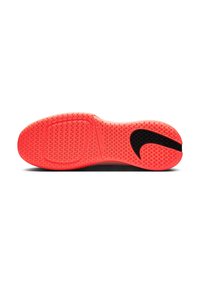 Helle rote Schuhsohle mit strukturiertem Grip-Muster und großem schwarzen Nike-Swoosh-Logo in der Nähe der Ferse, flach auf weißem Hintergrund präsentiert.