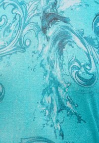 Tissu bleu avec des motifs aquatiques et floraux tourbillonnants complexes dans différentes nuances de turquoise et de sarcelle.