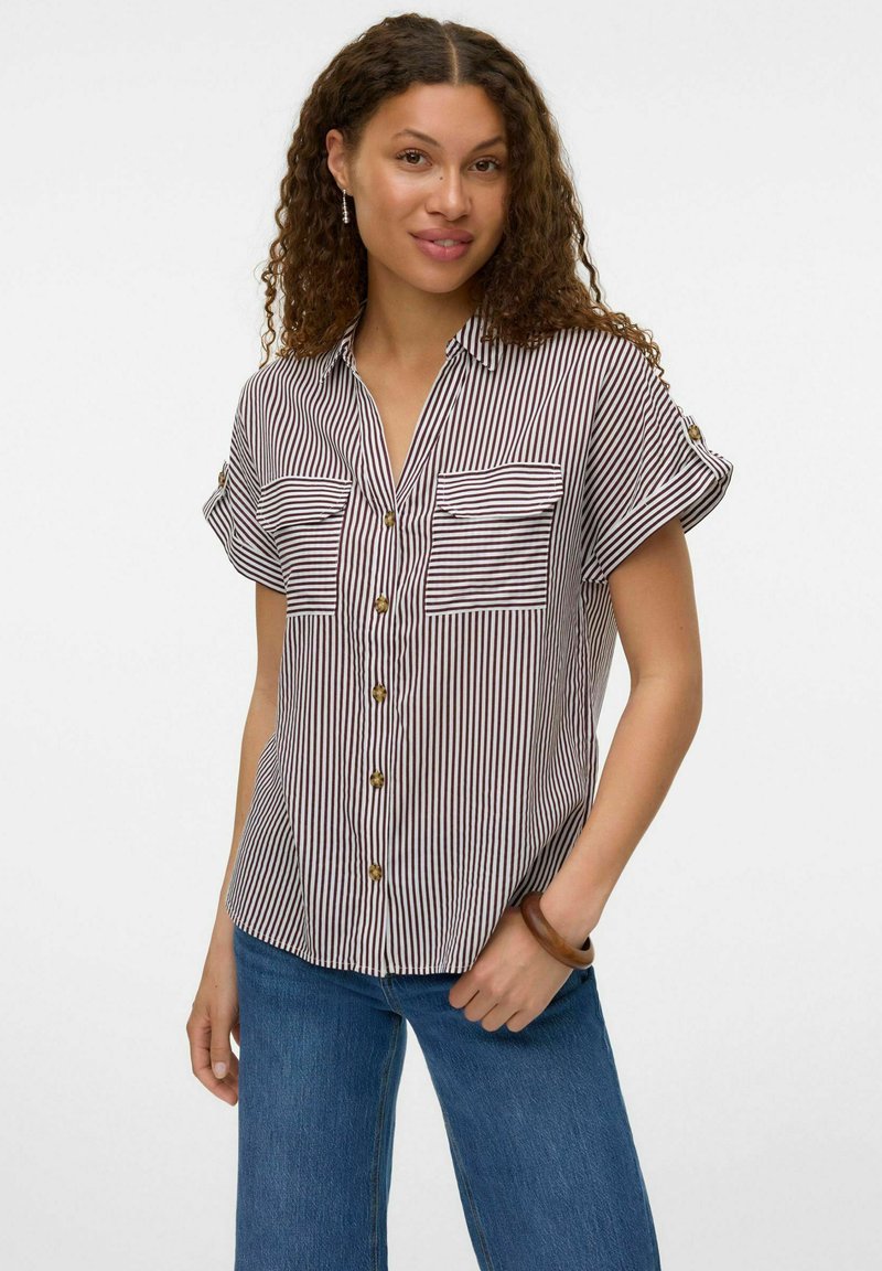 Chemise à manches courtes avec des rayures verticales bleu marine et blanches, deux poches poitrine, boutons dorés et un col. Coupe décontractée.